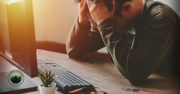Man in front of computer feeling stressed and anxious.