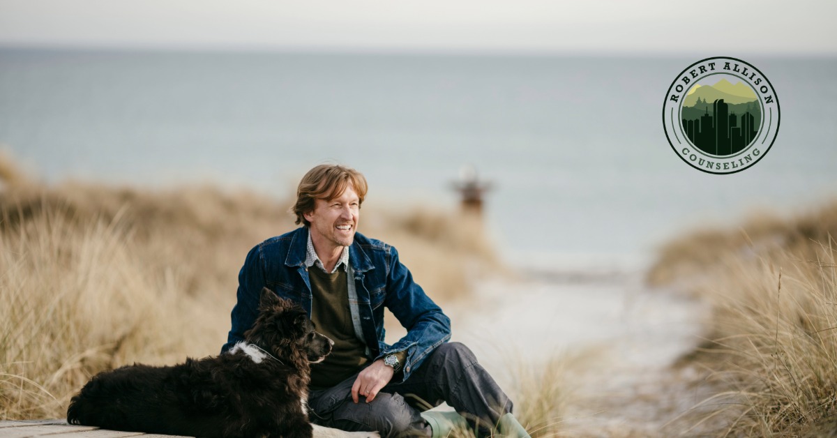 Man enjoying moment on beach with dog